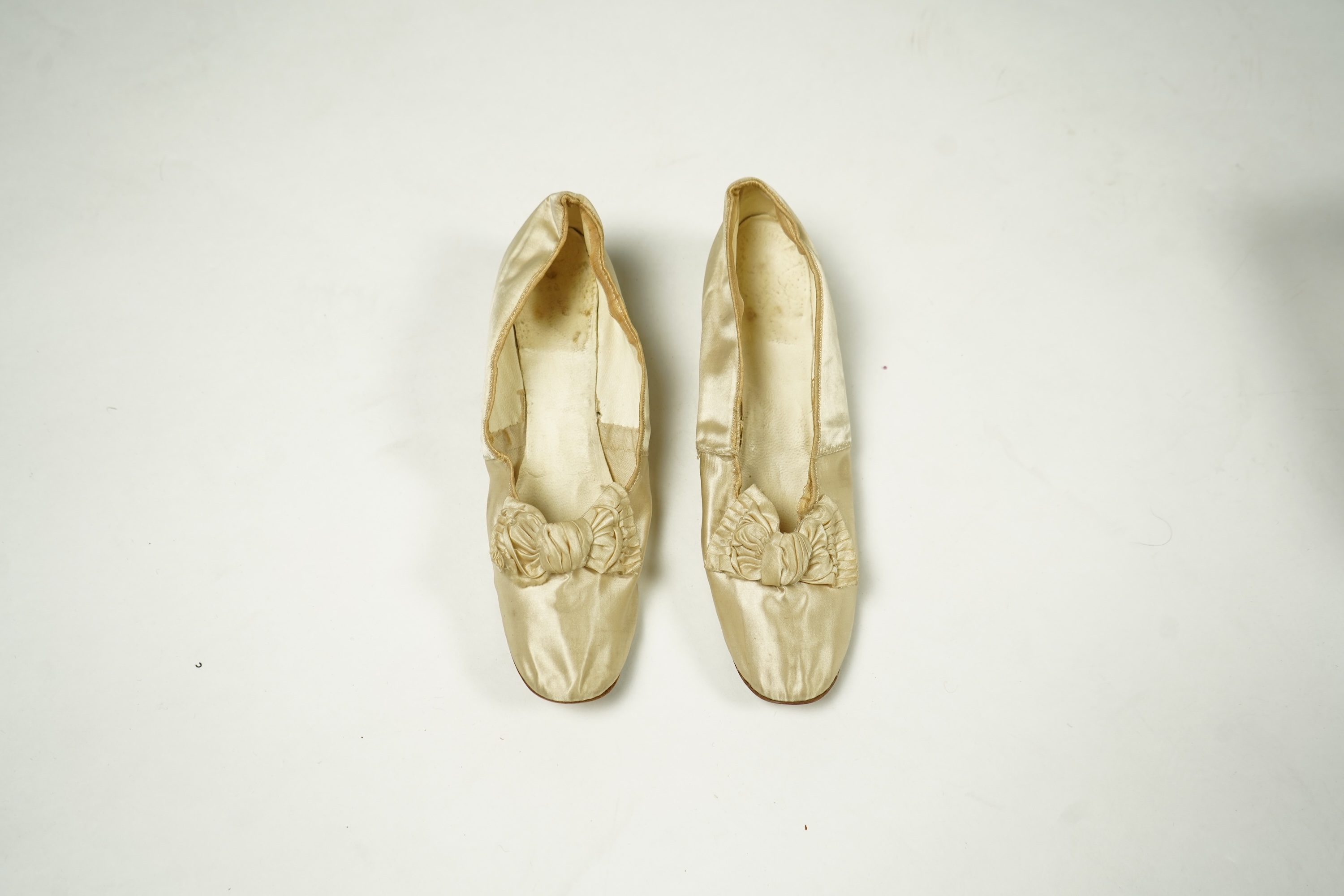 An unusual pair of Edwardian ladies red velvet and gold embroidered mules, a pair of 19th century ladies cream silk shoes and a pair of baby's embroidered suede shoes. Mules stamped 41at toe of sole. Condition - all thre